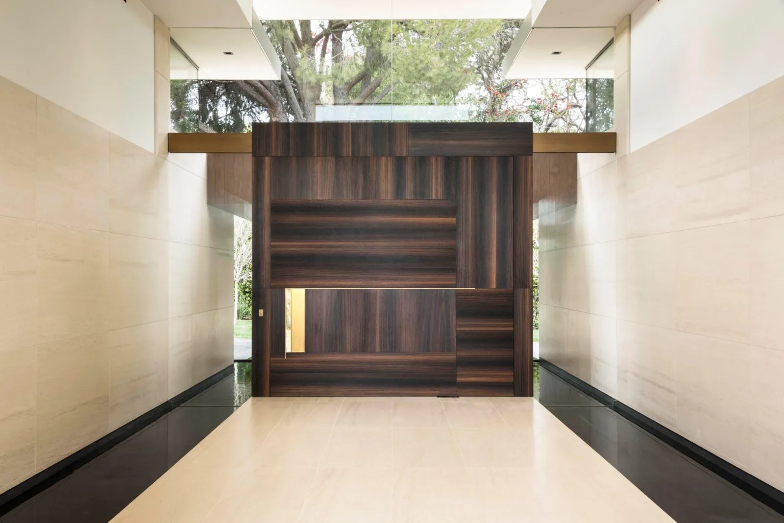 A dark timber entry at night, lit by one warm source — the atmosphere of the building after hours.