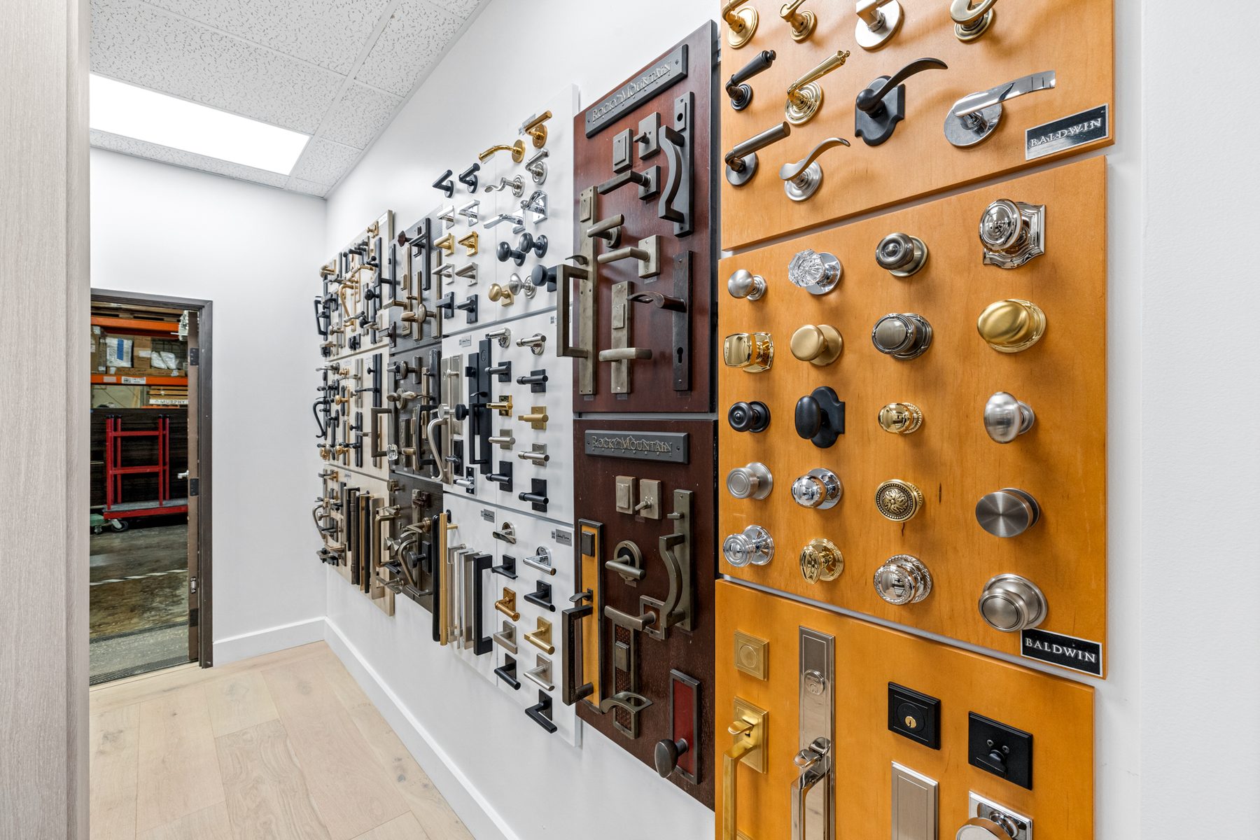 Fine Line's hardware sample wall: hundreds of levers, knobs, pulls and locksets mounted on boards.