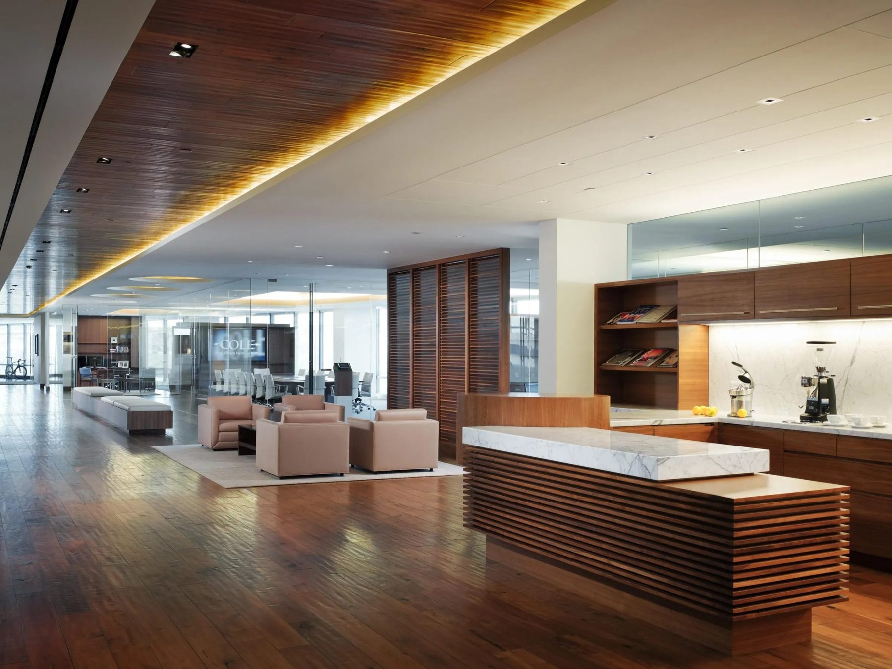 A commercial reception and lounge built by Fine Line: a slatted timber ceiling, a long stone counter and fitted joinery.